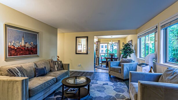 A spacious living room with a sofa, armchairs, a coffee table, and a dining area with a table and chairs. - the Lanai, Best Area, Large Balcony, WD, Condo (Tacoma)