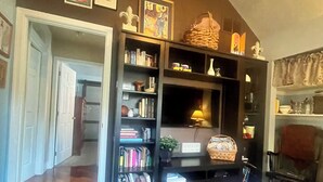 Uma sala de estar com uma estante de livros, uma lareira e uma placa com a inscrição "Cool Cape May".