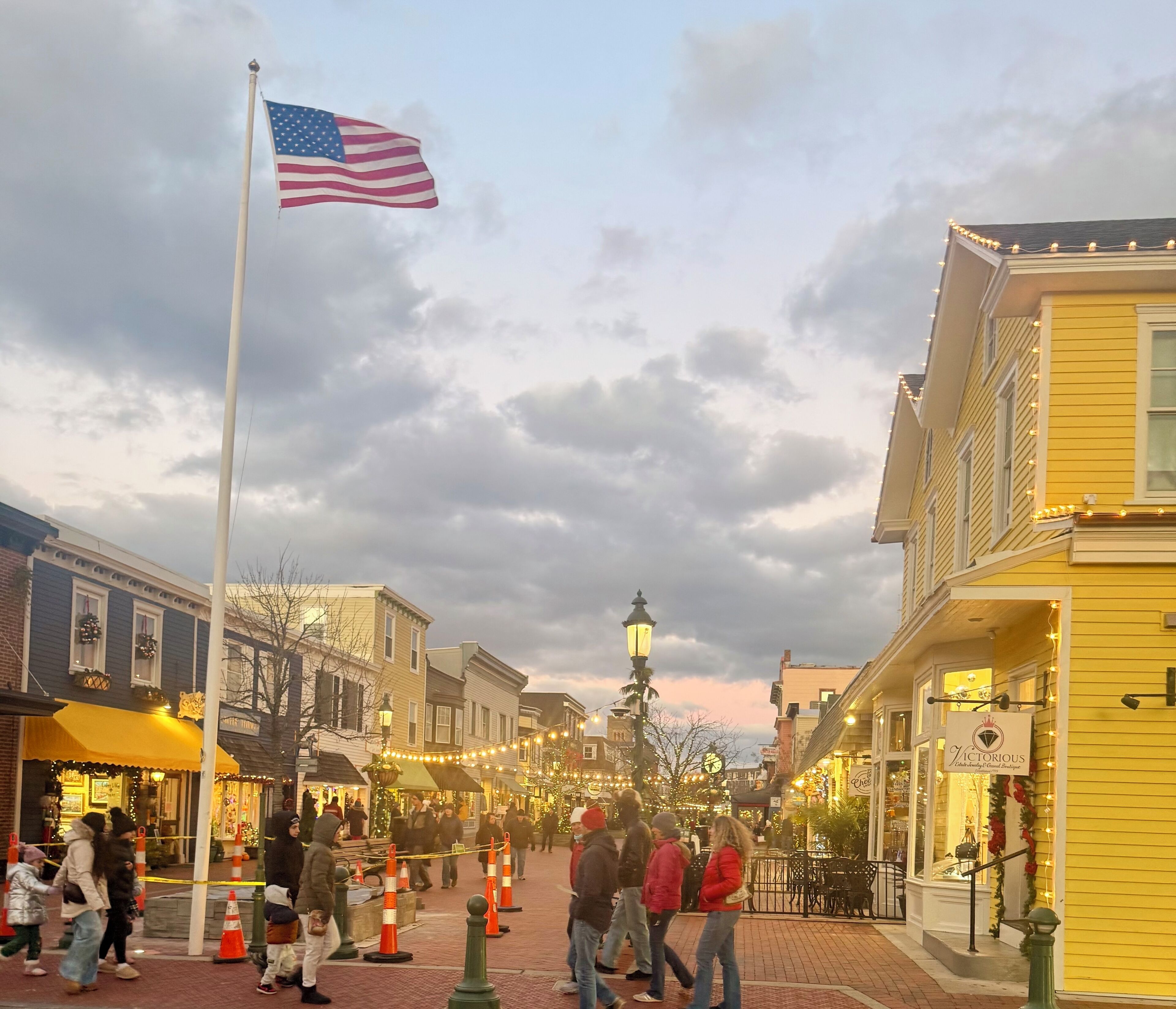 Eine Straße mit Gebäuden, einer amerikanischen Flagge und Fußgängern.