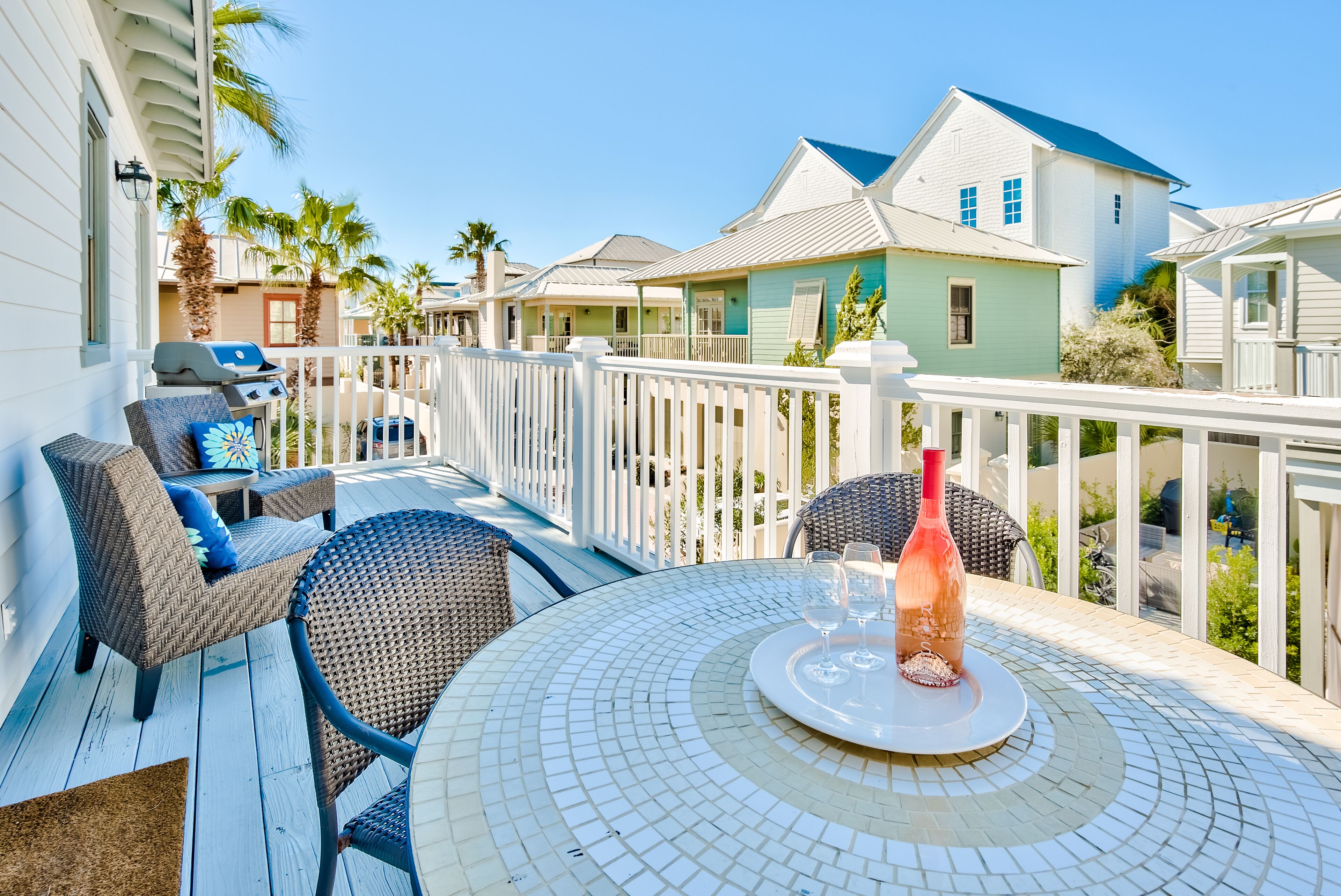 A covered outdoor area with a round table, chairs, and a grill.