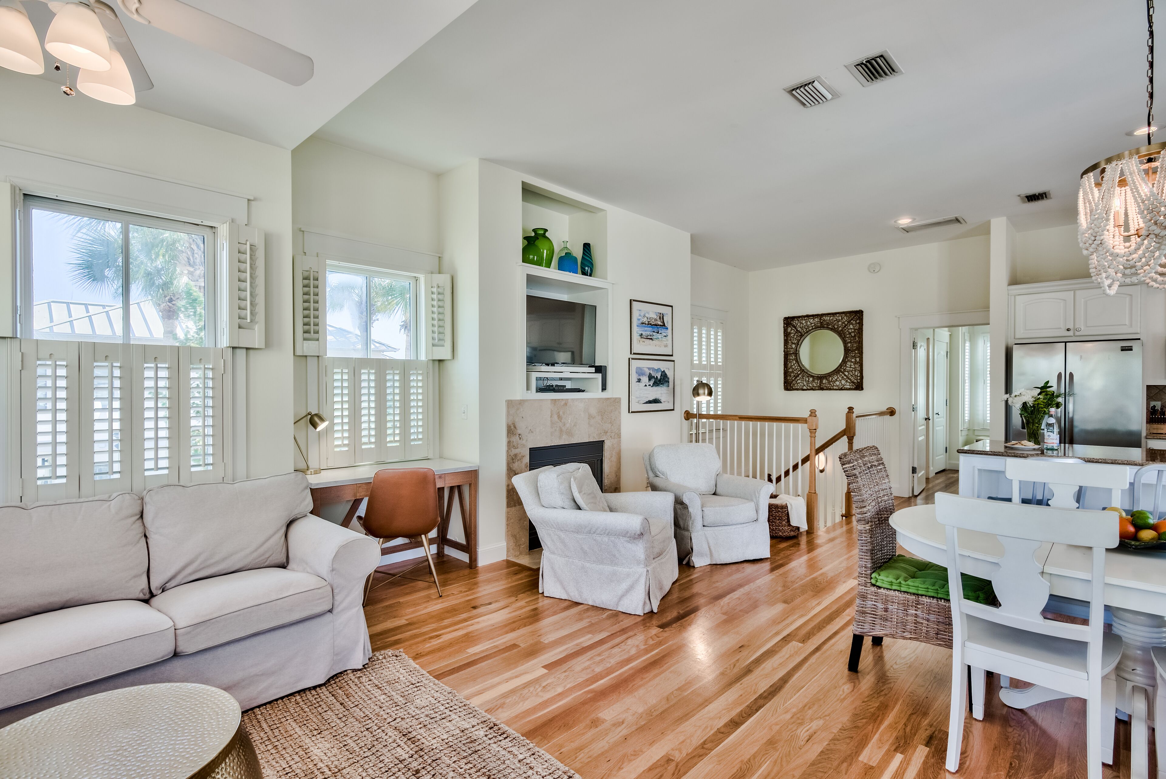A spacious living area with a sofa, chairs, a dining table, and a kitchen area.