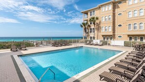 A swimming pool with lounge chairs, a view of the ocean, and a building with multiple balconies. - Gulf Front Pool + Bikes! South of 30A, Steps to Beach, between Alys & Rosemary (Seacrest Beach)