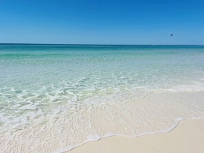 A beach with clear turquoise water and white sand.