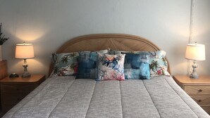 A bedroom with a bed, two nightstands, two lamps, a ceiling fan, and a hanging plant. - Panoramic Ocean and Sunset View in Poipu – Enjoy Lofty Haven Cross-Breezes! (Koloa)