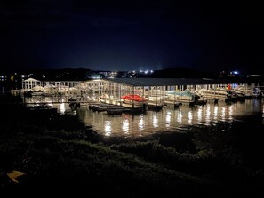 Marina à noite, com barcos atracados sob uma cobertura.