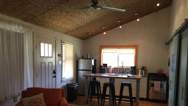 Un espacio habitable compacto con zona de cocina, una mesa de comedor y un sofá.