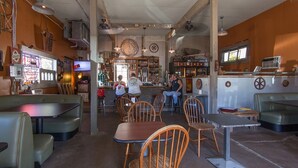 Interior de restaurante com cabines, mesas e um espaço de bar.