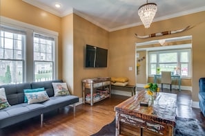 Relax in this stylish living room with a comfortable sofa, wooden coffee table, and large flat-screen TV.