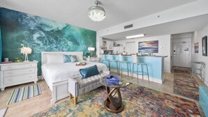 A modern bedroom with a large mural, a separate kitchenette, and a dining area. - Beachfront King Suite/Big Balcony! (Panama City Beach)