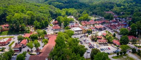 A town with a central square, surrounded by buildings with red roofs, and a parking lot in the foreground.
