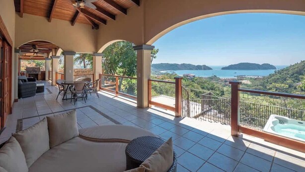 A covered outdoor seating area with a view of the sea and hills. - Overlooks Los Suenos Marina 5BR (Playa Herradura)