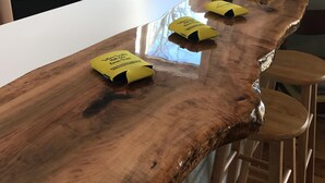 Une cuisine dotée d’un long comptoir en bois, d’un revêtement mural en carreaux blancs et d’une fenêtre donnant sur l’extérieur.