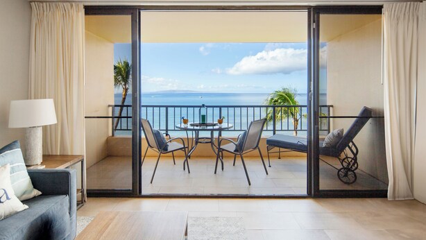 A balcony with a table and chairs, a sofa, and a lamp. - COMPLETELY REMODELED Sugar Beach Oceanfront Penthouse Sunset & Ocean View (Kihei)