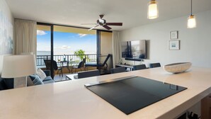 A modern hotel room with a large balcony, a dining area, and a kitchen. - COMPLETELY REMODELED Sugar Beach Oceanfront Penthouse Sunset & Ocean View (Kihei)