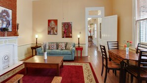 Un salon avec une cheminée, un canapé, une table basse et une table à manger avec des chaises.
