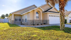 A single-story house with a garage, a front lawn, and a palm tree. - Hakuna Ma'Cottage - Minecraft Room, Southern Pool! (Kissimmee)