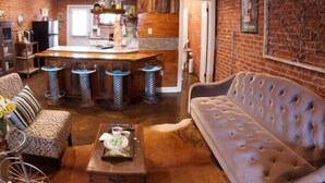 A cozy living room with a sofa, a coffee table, and a bar area with stools.