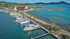 A marina with boats docked, a pier, and a building with a red roof. - Beach Resort  Walk-Out Patio with St. John Views (St Thomas)