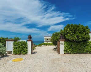 Ein Kiesweg führt zu einem Gebäude mit Blick auf das Meer.
