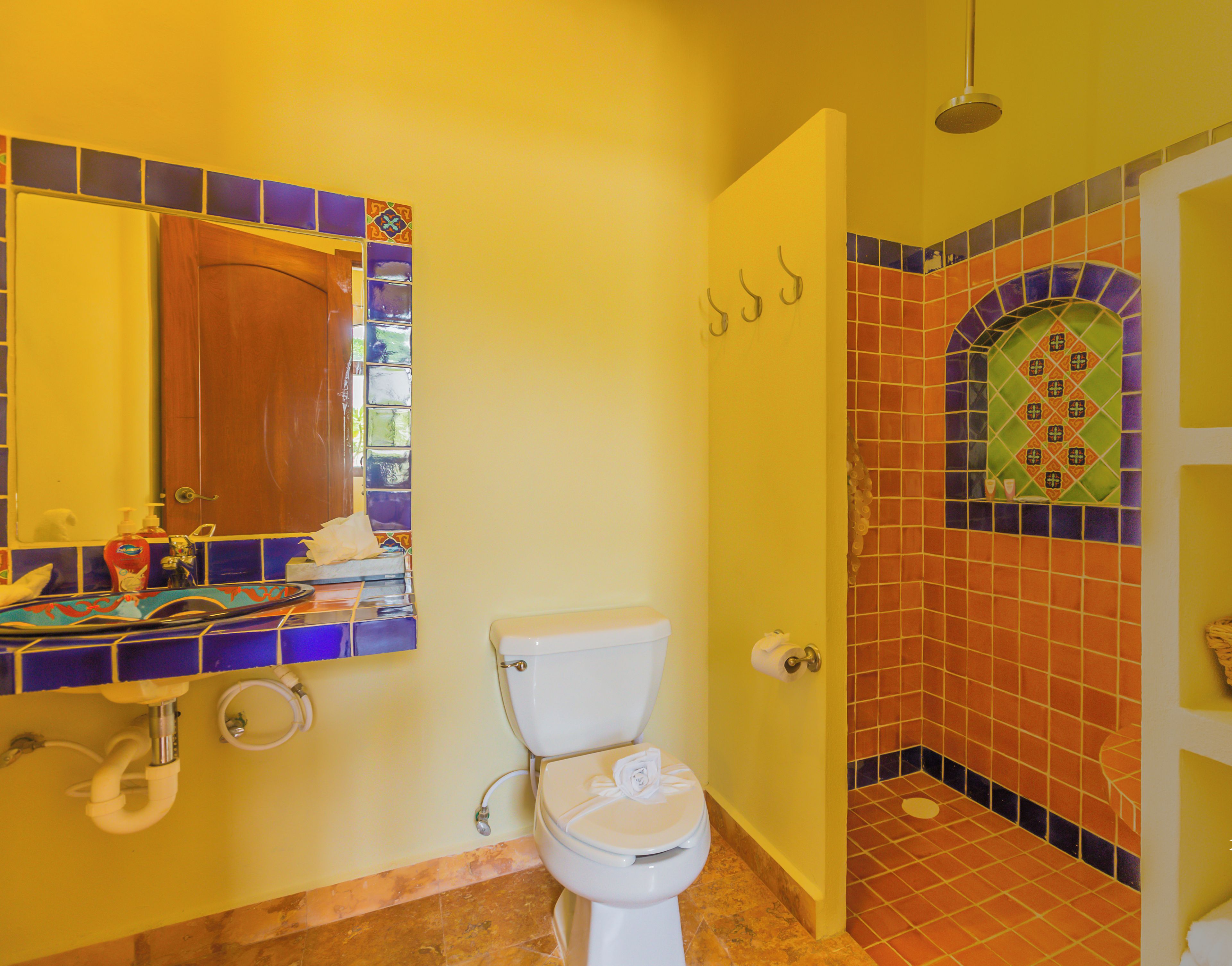 Une salle de bain comprenant des toilettes, un lavabo et un espace douche.