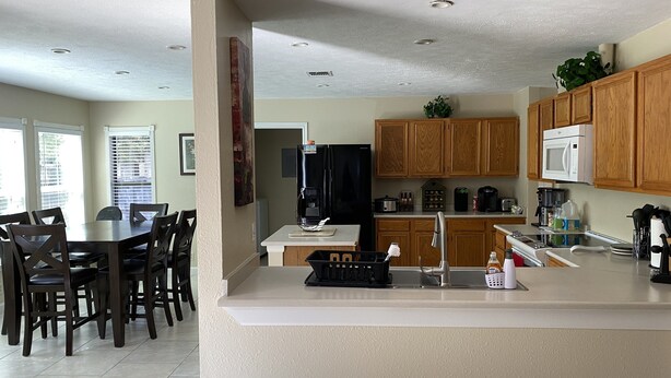 A modern kitchen with wooden cabinets, a built-in microwave, and a coffee maker.