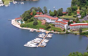 An aerial view of a lakeside property with a marina, multiple buildings, and a well-maintained lawn.