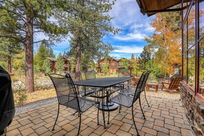 A patio with a table and chairs, surrounded by trees and a view of cabins. - Schaffer's Mill, Golf, Ski and Lake Tahoe, Club Amenities 3Br 3.5Ba Lodge! (Truckee)