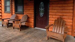 A wooden cabin with a porch, two Adirondack chairs, and a door with a decorative glass design. - Rustic yet Modern Log Cabin, Cayuga Wine Trail, Dog Friendly, Open Year Round (Ovid)