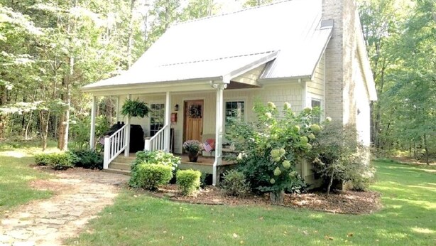 A single-story house with a covered porch, a front entrance, and a small front yard with a pathway leading to the door.