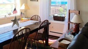 A dining area with a table, chairs, and a view of the ocean.