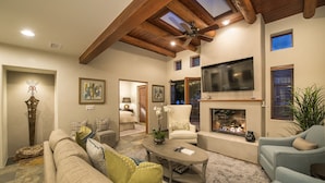 A living room with a fireplace, a sofa, a coffee table, and a TV mounted on the wall. - In The Heart Of Santa Fe, Walk to Everything Downtown, 3 Bed, 3 Bath Townhouse (Santa Fe)