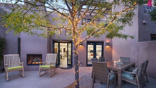 An outdoor patio with a dining table, chairs, and a fire feature. - In The Heart Of Santa Fe, Walk to Everything Downtown, 3 Bed, 3 Bath Townhouse (Santa Fe)