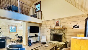 A spacious living area with a fireplace, a television, and a dining area.