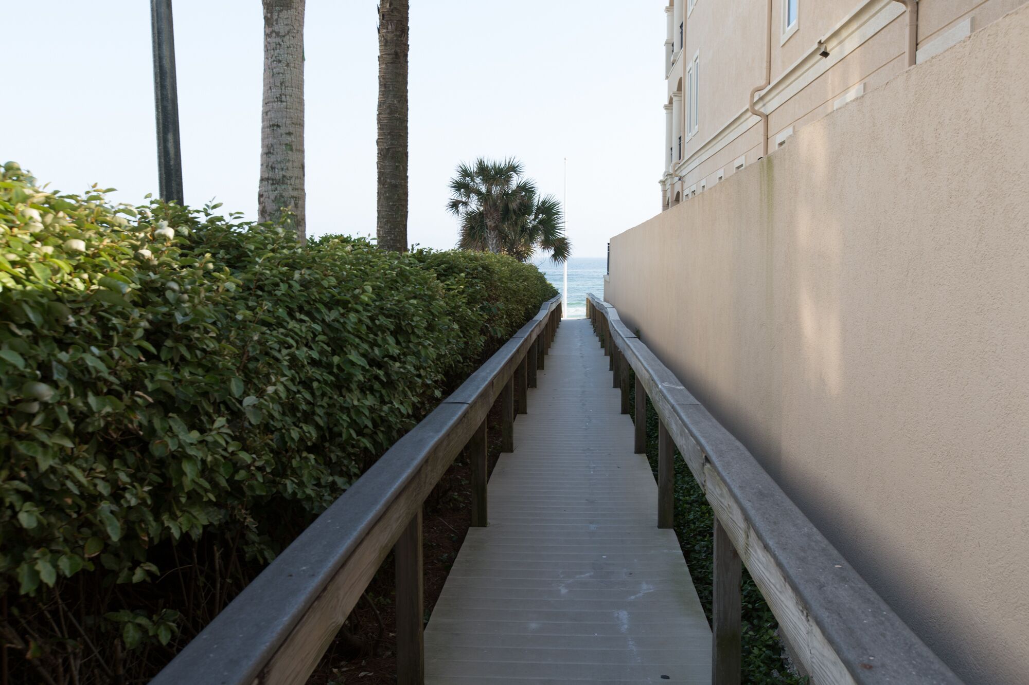 A pathway leading to a building with a view of the ocean.