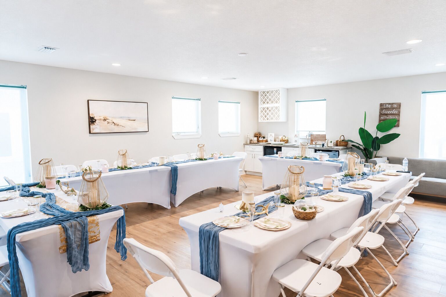 A conference room with white tables, blue tablecloths, and white chairs.
