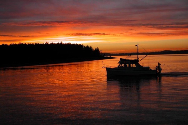 View from living room of a gorgeous sunset with a boat coming into the bay
