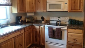 A kitchen with wooden cabinets, a microwave, a stove, and a toaster.