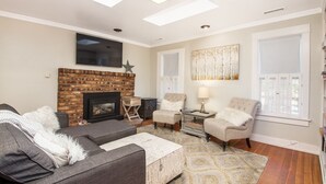 A living room with a fireplace, a sofa, a chair, and a patterned rug. - Historic Dowtown Home.  Walk To shops, Restaurants, NAU (Flagstaff)