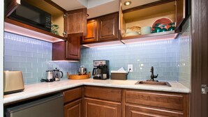 A kitchen with wooden cabinets, a microwave, a coffee maker, and a sink. - A 'Spa feel' at the Diamond Head Beach Hotel🕉 (Honolulu)