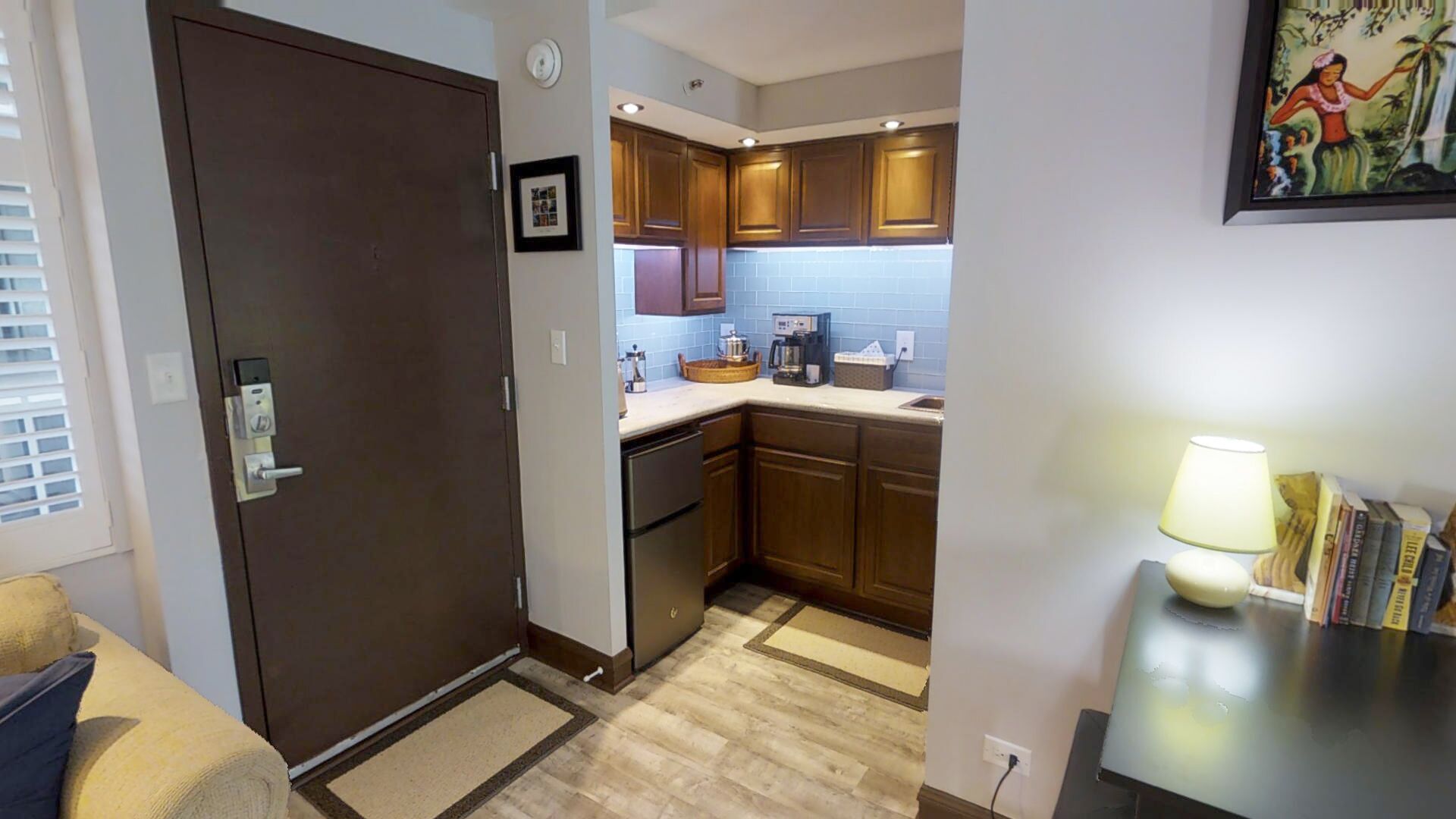 A compact kitchen with wooden cabinets, a coffee maker, and a small countertop.