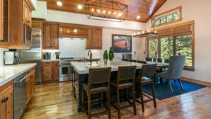 Una cocina amplia con armarios de madera, una isla grande y un comedor con sillas.