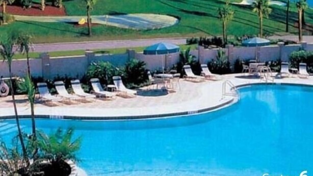 Een resort met een zwembad, een golfbaan en uitzicht op het omliggende landschap.