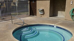 A swimming pool with a tiled edge, a metal ladder, and a wall-mounted water fountain. - "Condo Du Jour!"  Remodeled!  Comfortable King Bed!   (Saint George)