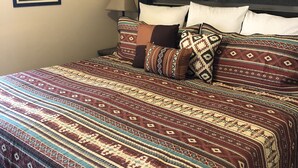 A neatly made bed with patterned bedding, a headboard, and wall-mounted picture frames. - "Condo Du Jour!"  Remodeled!  Comfortable King Bed!   (Saint George)
