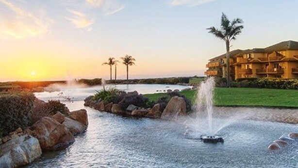 A resort with a pool, palm trees, and a building with multiple balconies. - Seascape Resort 2B Luxury Oceanview Villa, Steps From The Beach, 5 min to golf (Aptos)