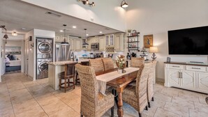 A spacious kitchen with a dining area, built-in appliances, and a large TV. - Lake Conroe WATERFRONT Updated 3BR Condo with Pools, Paddle Boards & Views (Montgomery)