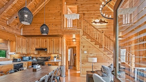 A wooden cabin interior with a kitchen, dining area, and a staircase. - Mtn View Cabin 5 min to Downtown Blue Ridge w/Hot Tub and Firepit, Pet Friendly! (Blue Ridge)