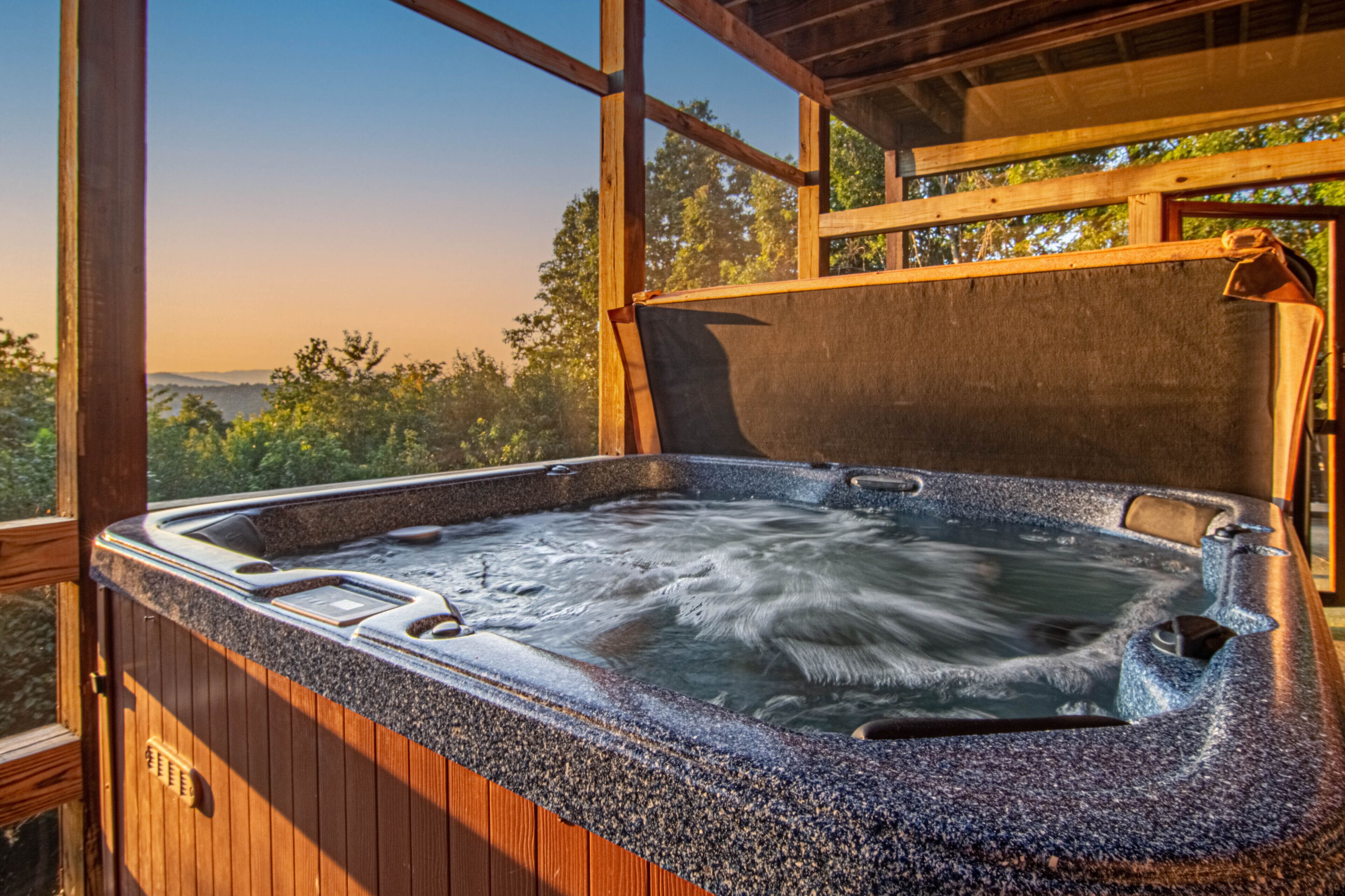 Ein Whirlpool mit Holzverkleidung und Blick ins Freie.