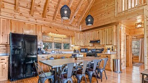 A wooden cabin interior with a large kitchen area, dining table, and chairs. - Mtn View Cabin 5 min to Downtown Blue Ridge w/Hot Tub and Firepit, Pet Friendly! (Blue Ridge)