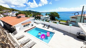 A rooftop pool with lounge chairs and a view of the sea. - Gated "Sea Breeze" House Overlooking the Caribbean (Patillas)